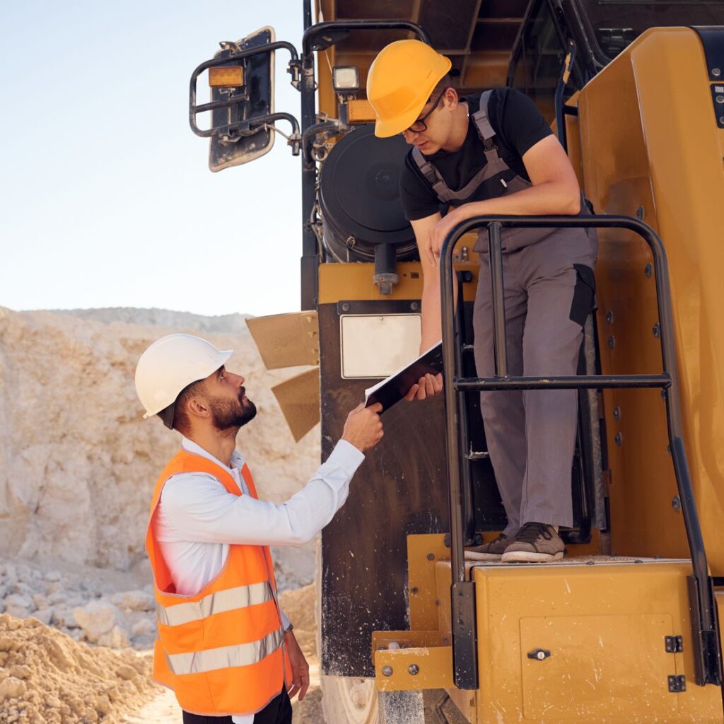Taking the documents. Two men in uniform are working together in the quarry